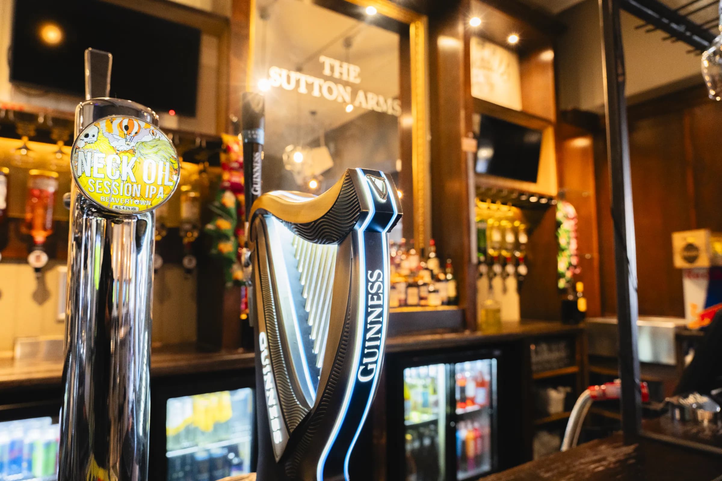 Guinness and Neck Oil taps on the bar in front of the Sutton Arms mirror